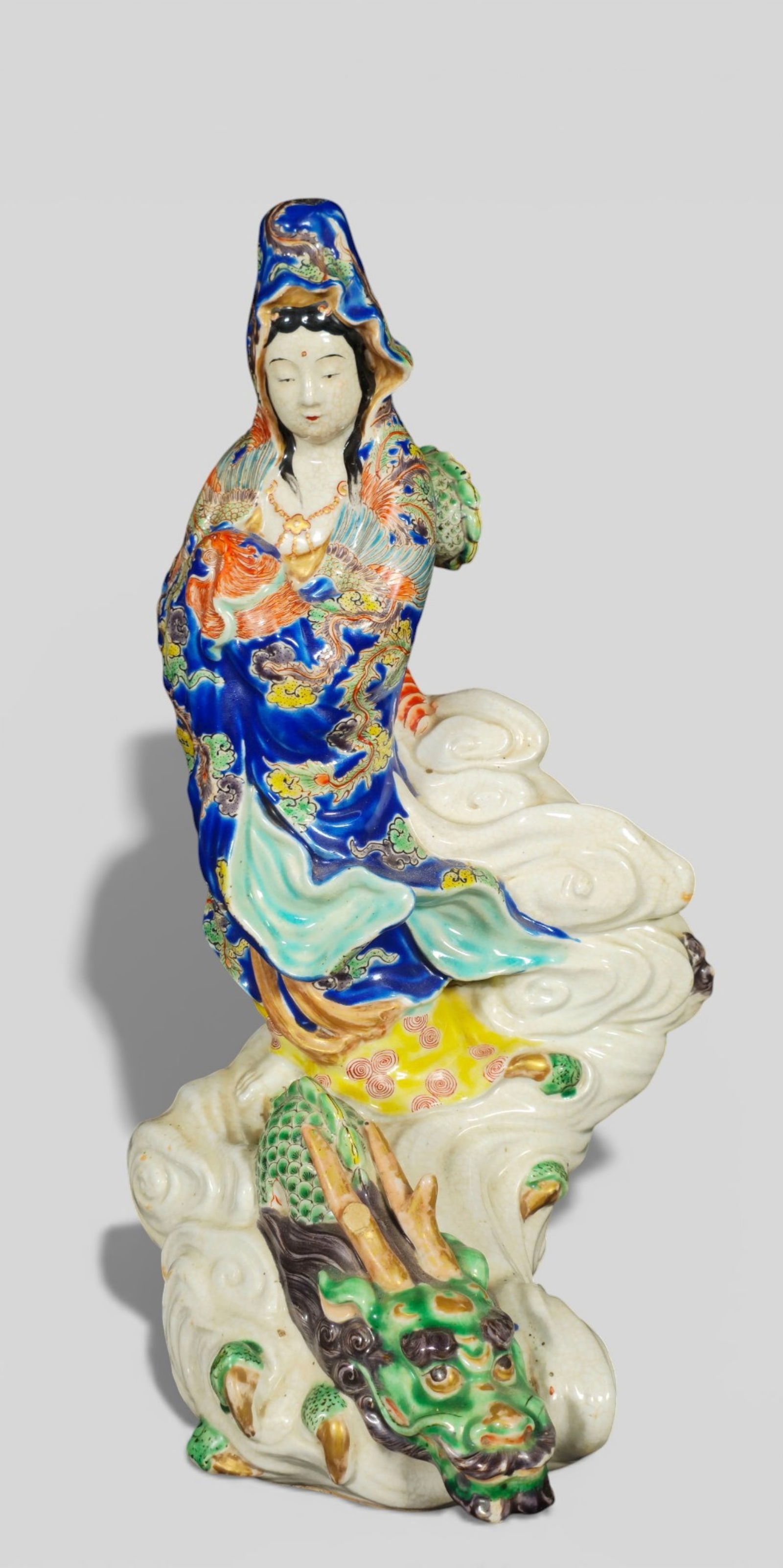 19th‑Century Japanese Kutani Porcelain Bodhisattva Riding a Dragon: 19th‑Century Japanese Kutani Porcelain Bodhisattva Riding a Dragon. Dynamic 19th‑century Japanese Kutani porcelain figure of a bodhisattva seated atop a sinuous dragon emerging through swi