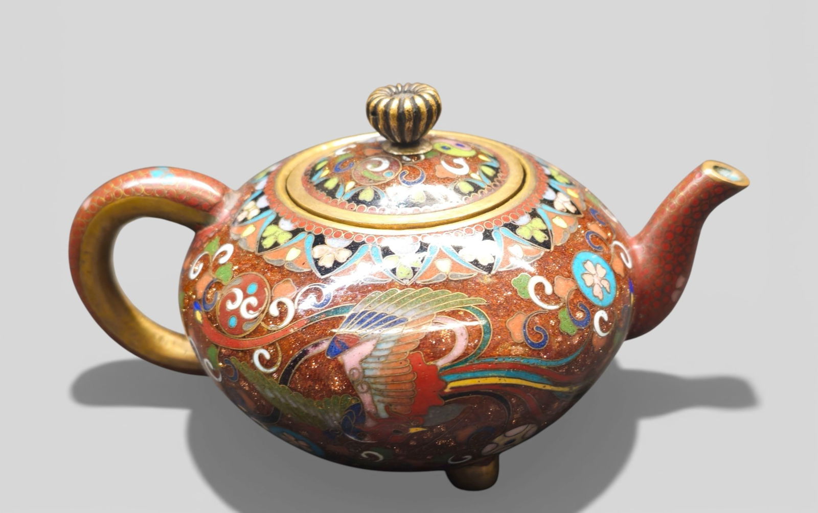 Japanese Cloisonné Enamel Miniature Teapot, Meiji Period: Japanese Cloisonné Enamel Miniature Teapot, Meiji Period. Circa 1868-1912. Intricate floral decoration with pheasants and scrolling; brass floral lid handle. 5w x 3 1/2d x 3h.