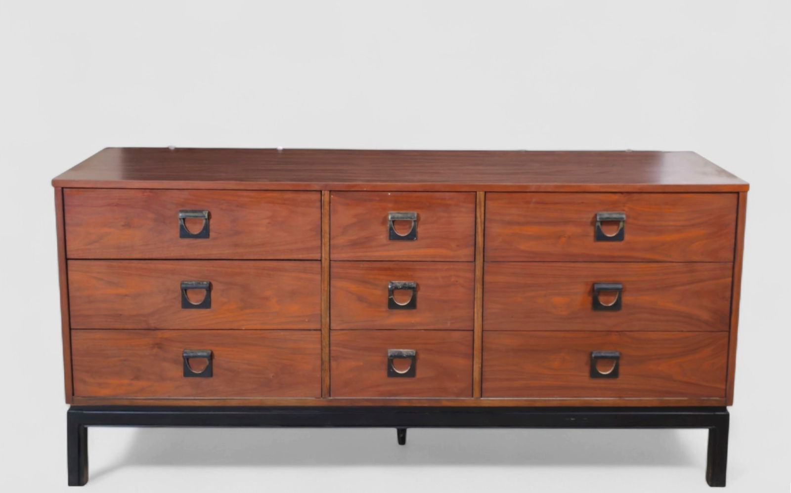 Dixie MCM Walnut Dresser: Dixie MCM walnut dresser featuring nine drawers arranged in a symmetrical three-by-three configuration, each fitted with sculptural recessed metal pulls. The case rests on a clean-lined ebonized
