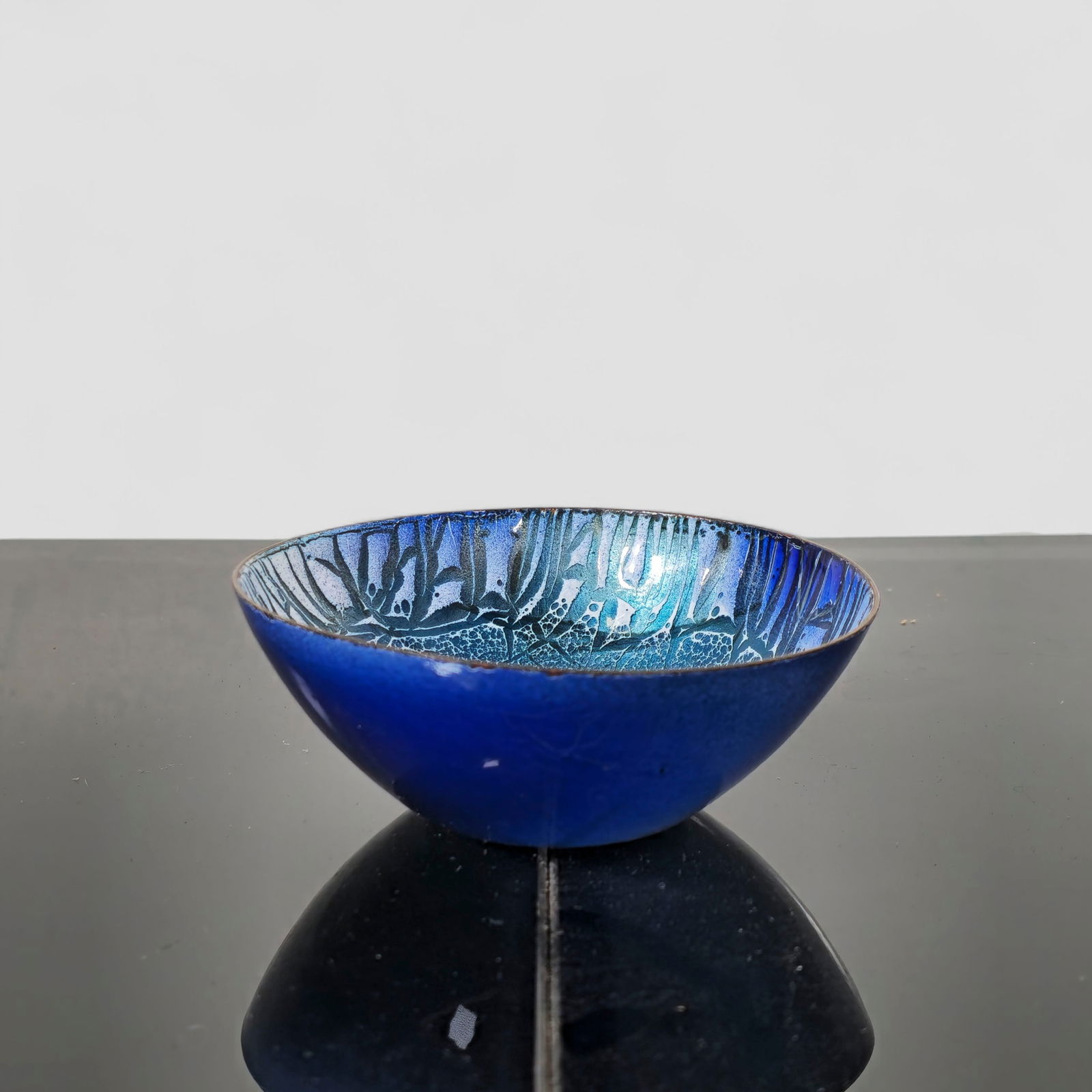 Edward Winter Enamel Studio Bowl: A mid-century enamel-on-copper art bowl by American enamelist Edward Winter, featuring rich blue tones with abstract interior patterning and a smooth, glossy exterior. Signed "Winter" to underside. A