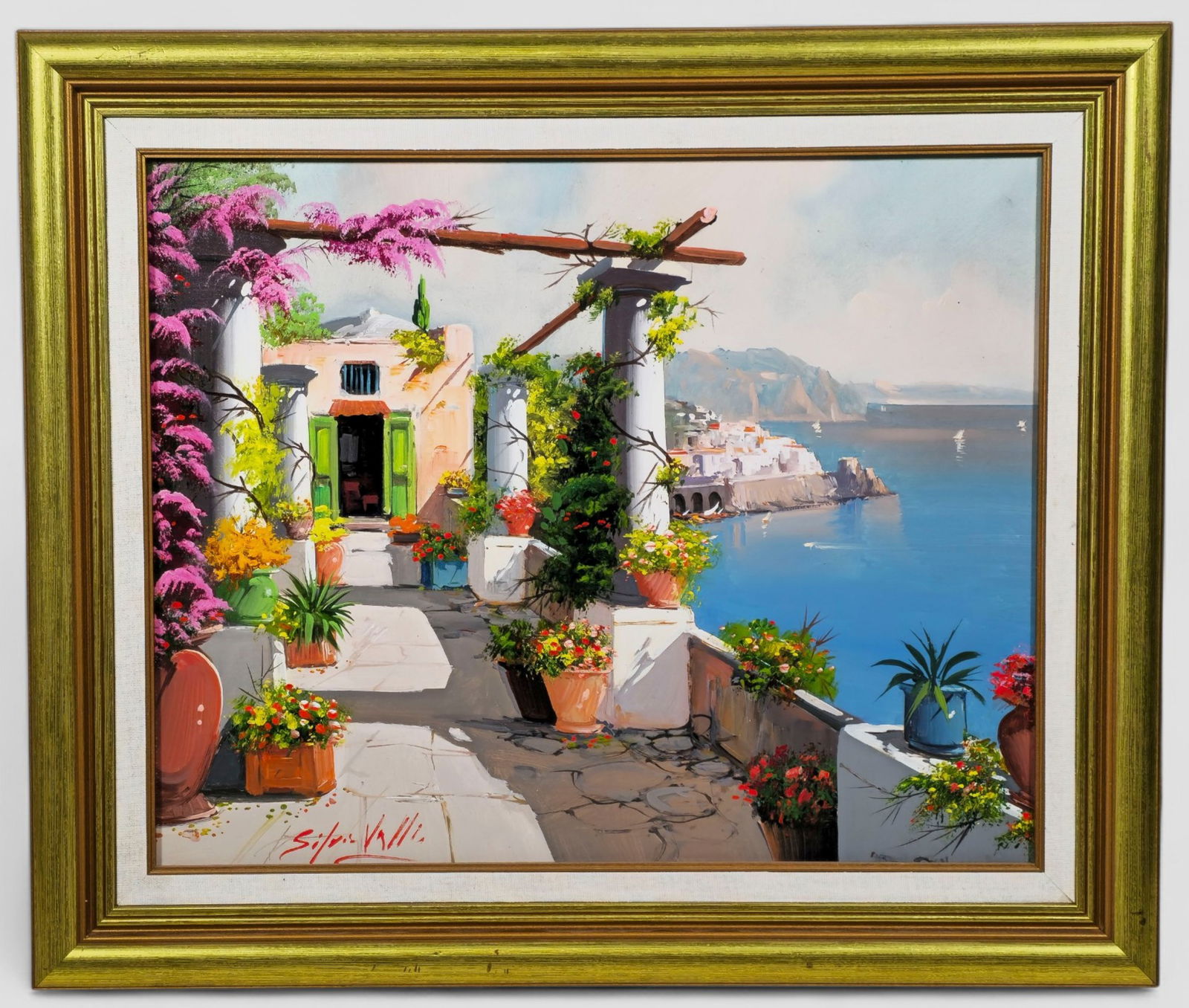 Silvio Valli "Mediterranean Terrace" Oil Painting: Silvio Valli (Naples, Italy, 20th Century), vibrant oil painting of a sunlit Mediterranean terrace overlooking a coastal village and brilliant blue sea. The scene features lush flowering plants,
