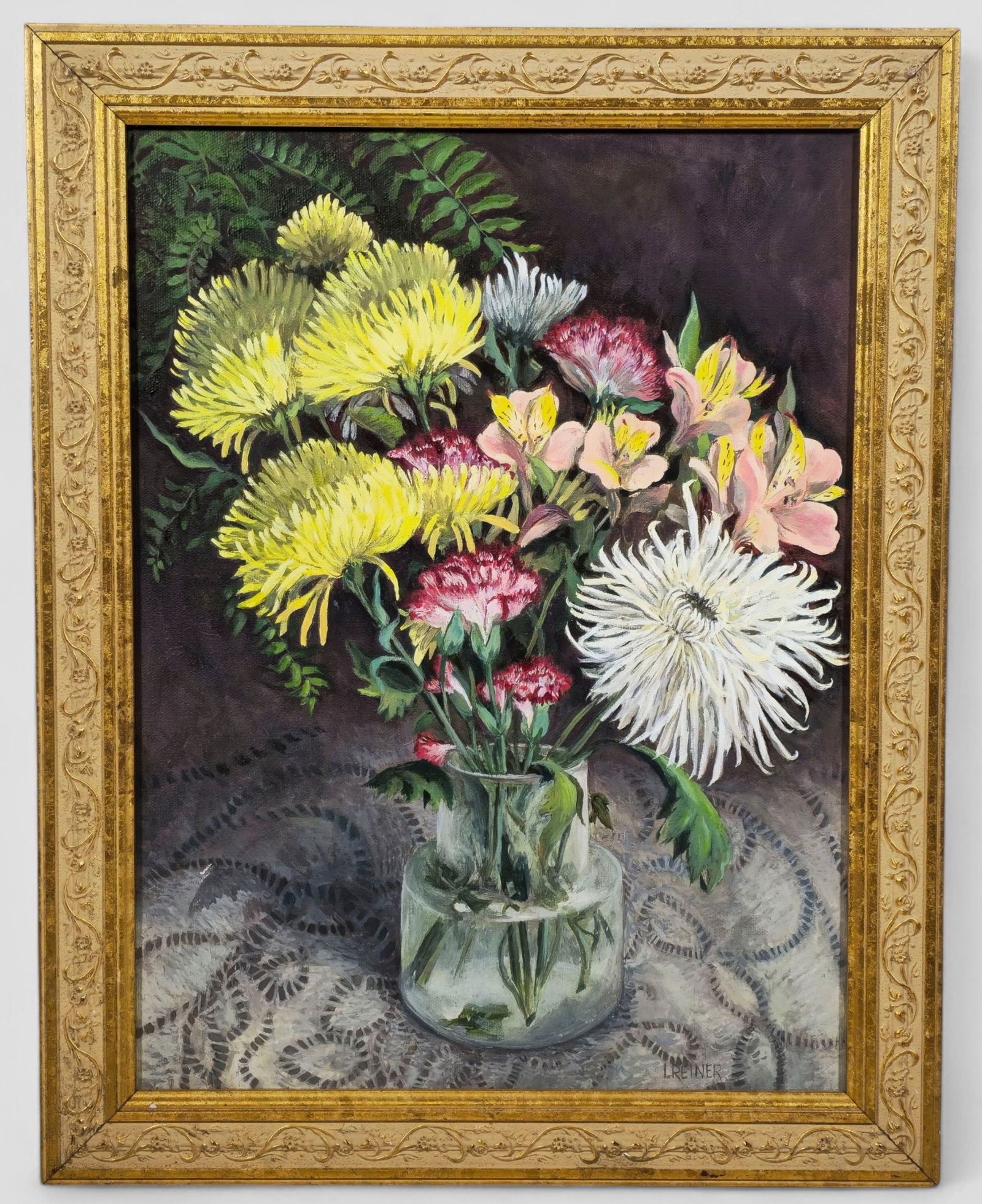 Lucas Reiner "Floral Still Life" Oil Painting: Lucas Reiner (American, 1960– ), detailed oil still life depicting a glass vase filled with chrysanthemums, carnations, alstroemeria, and ferns arranged atop a patterned lace tablecloth. Rich,