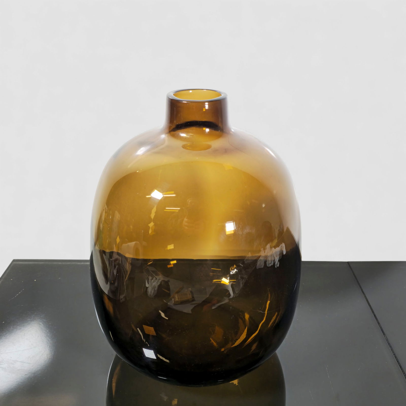 MCM Murano Amber Art Glass Vase: Hand-blown Murano art glass vase with a rounded ovoid body, narrow cylindrical neck, and rich smoky amber coloration that deepens toward the base. Polished pontil underside. Elegant modern decorative