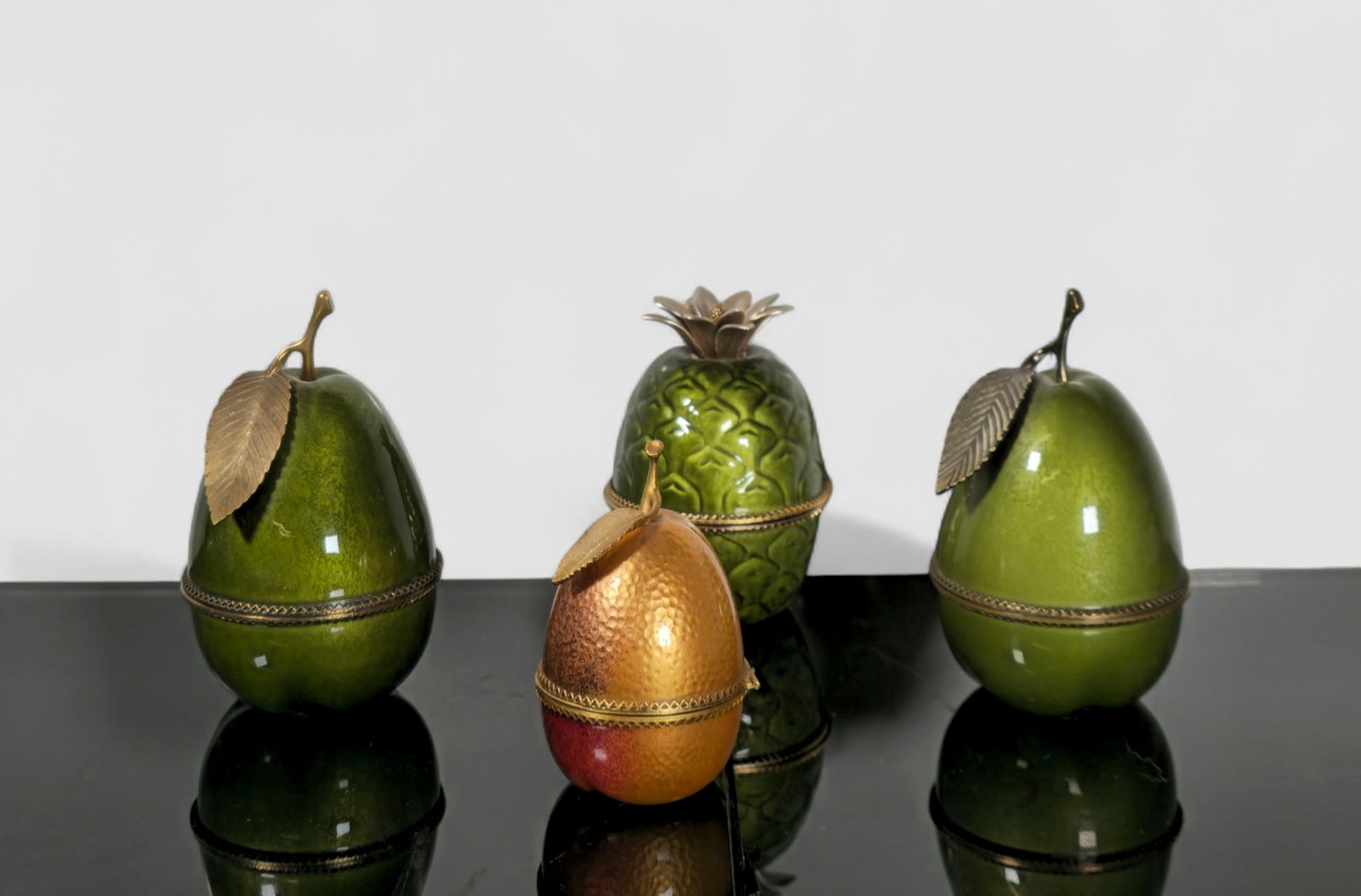 Evans Enamel Table Lighters: Evans Enamel Table Lighters. Set of 4. 1960s. Manufacturer's label to interior. Enamels fruit and gold tone metal. Pineapple- 3 1/4dia x 4 1/4h Pear- 3dia x 5 1/4h.