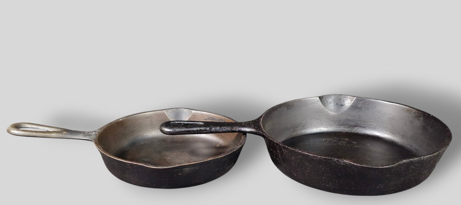 Griswold #5 and Wagner Ware #3 Cast Iron Skillets: Griswold #5 and Wagner Ware #3 Cast Iron Skillets. Circa 1920s. Manufacturer's marks to underside. Wagner stamped to underside #10530. Griswold 8 3/4w x 12 1/2d x 2h. Wagner 7w x 10 3/8d x 1 3/4h.