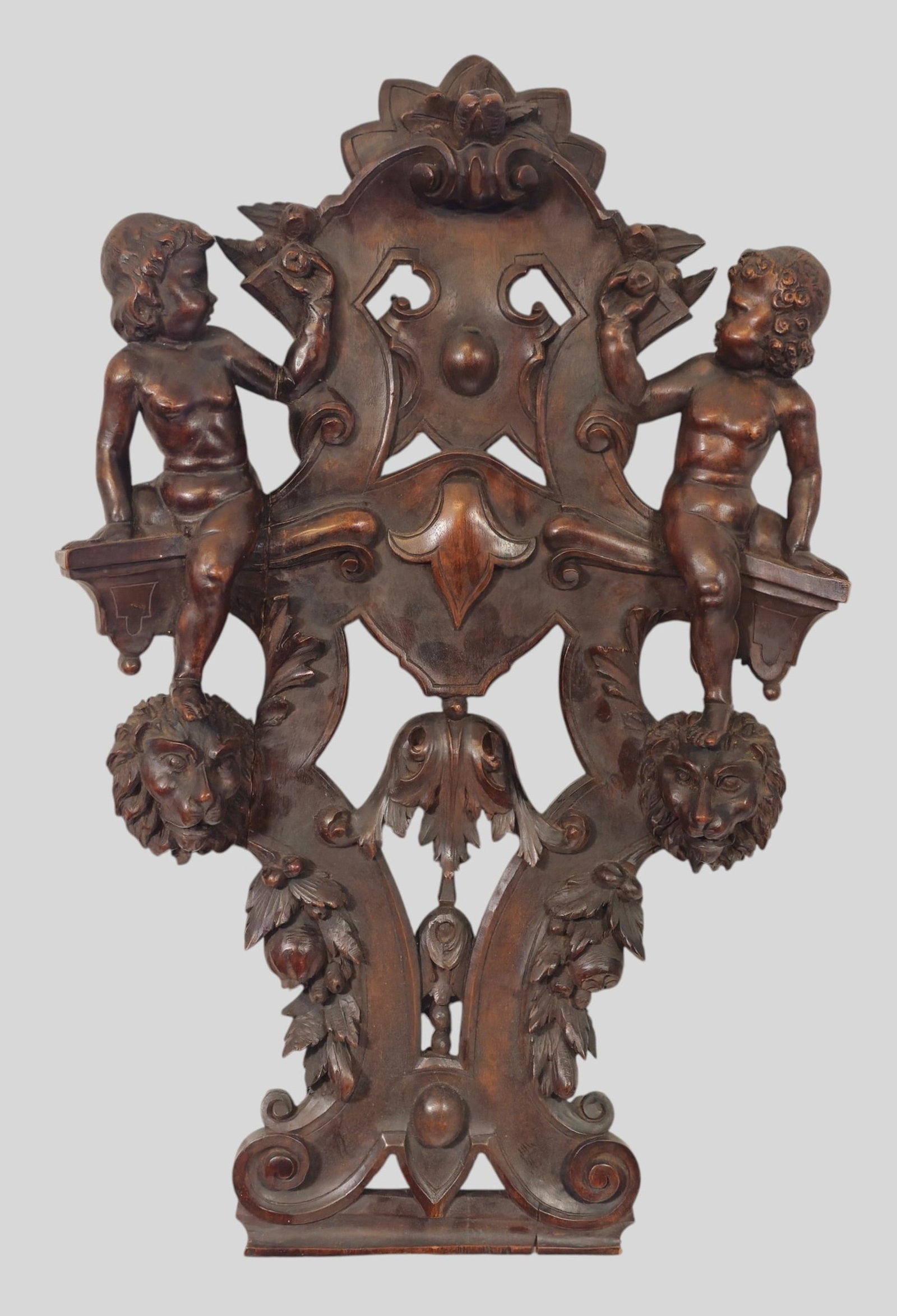 19th Century Italian Carved Walnut Sgabello Chair Back: 19th Century Italian Carved Walnut Sgabello Chair Back. Circa 1880. Carved cherubs resting on lion head supports. 19w x 4d x 30h.