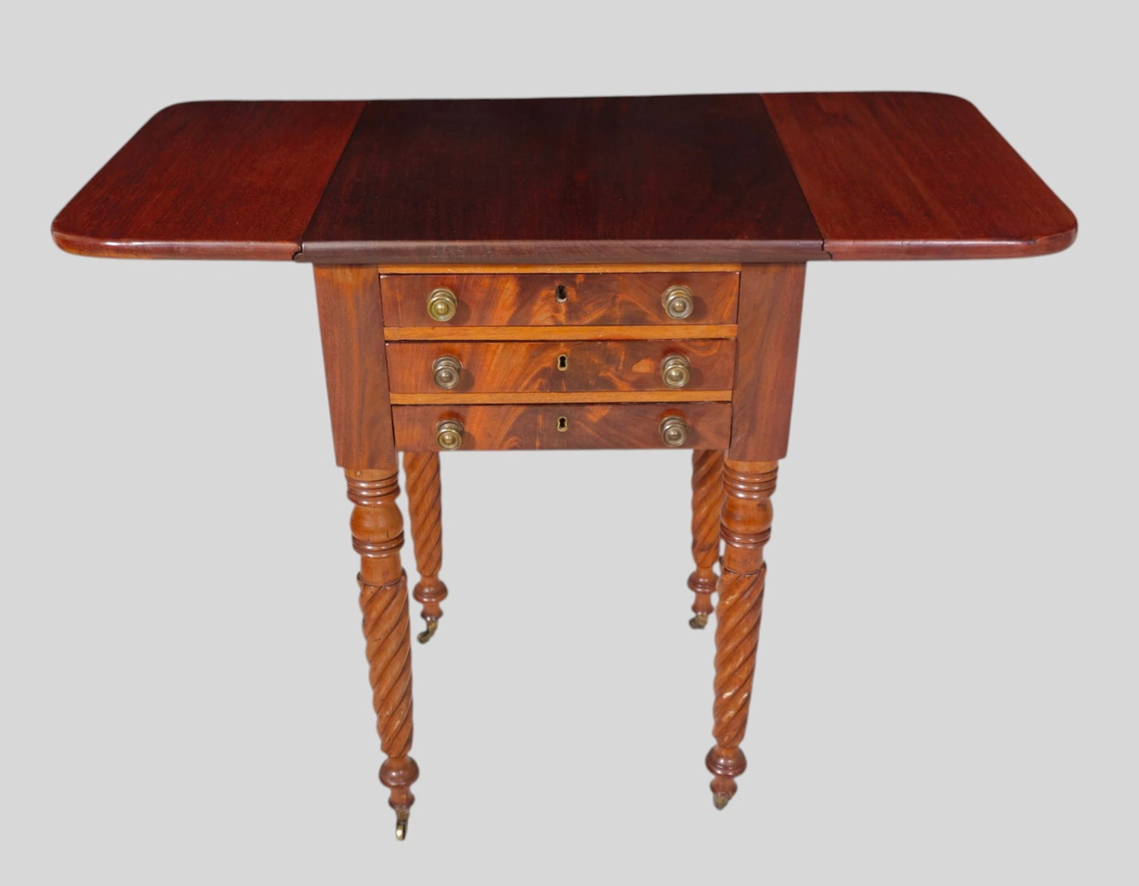 19th Century Mahogany Stand: 19th Century Mahogany Stand. Circa 1860. 3 drawers with original brass pulls. Drop side and turned legs. Closed 18 1/2w x 18d x 28 1/2h. Extended 34 3/4w x 18d 28 1/2h.
