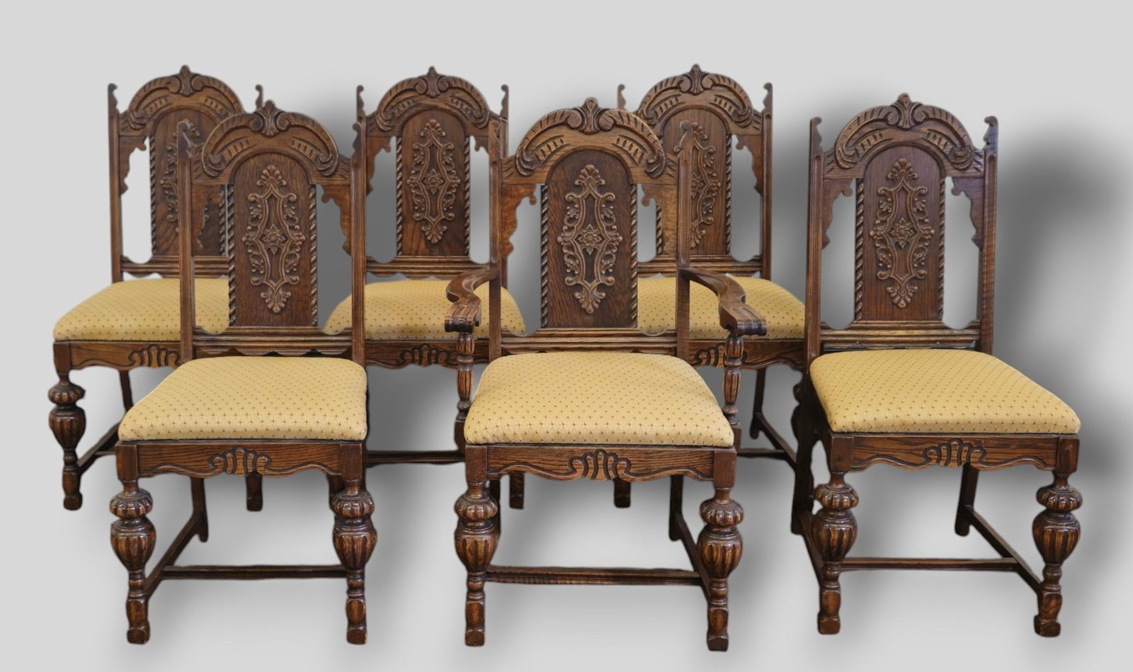 Carved Oak Dining Chairs: Jacobean Style carved oak dining chairs. Set of 6. 1 arm and 5 side . 1920s. Renaissance Revival. 225 3/4w x 24 1/2d x 42h, Sh 20 1/2. Side chairs 22w x 24 1/2d x 42h, Sh 20 1/2.