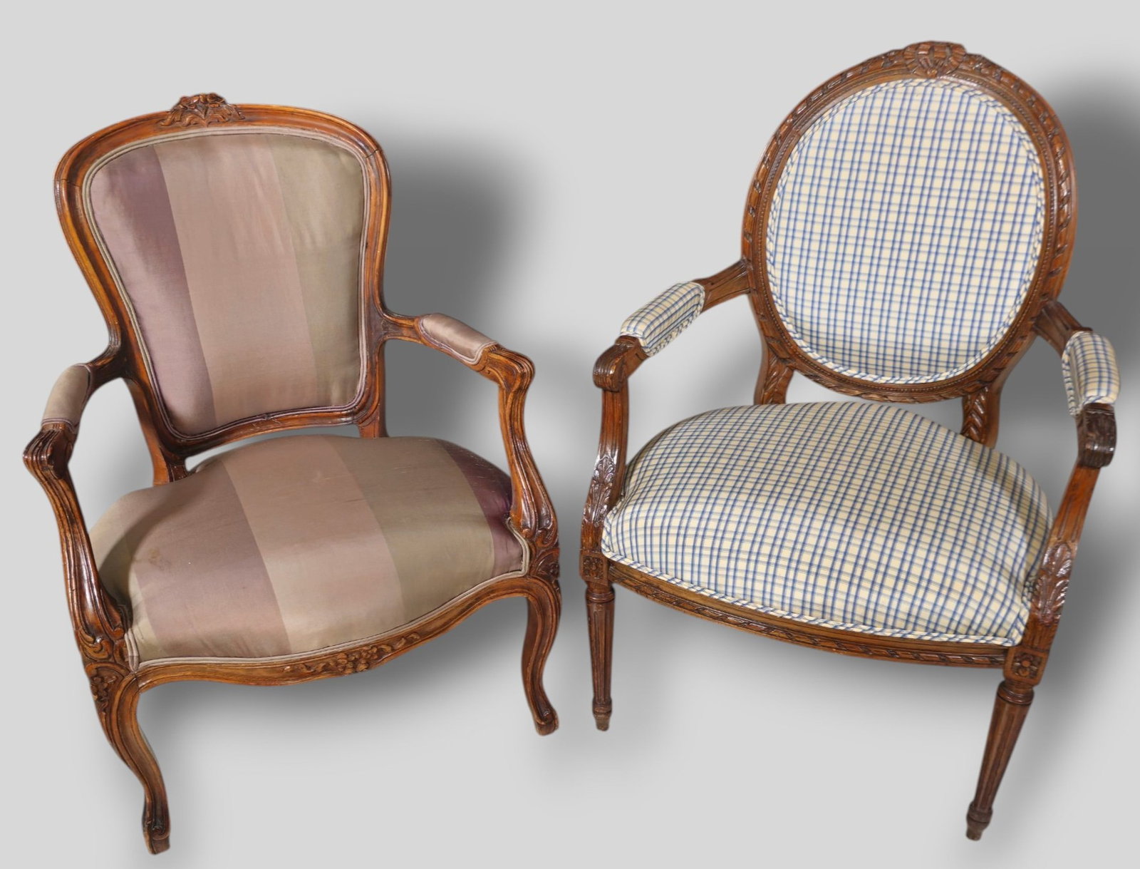 French Louis XV Carved Upholstered Armchairs: French Louis XV Carved Upholstered Armchairs. Circa 1920s and 1940s. Carved and sculptured walnut frames with silk upholstery. 1920s chair has turned fluted legs. 1940s chair has cabriole legs. 25