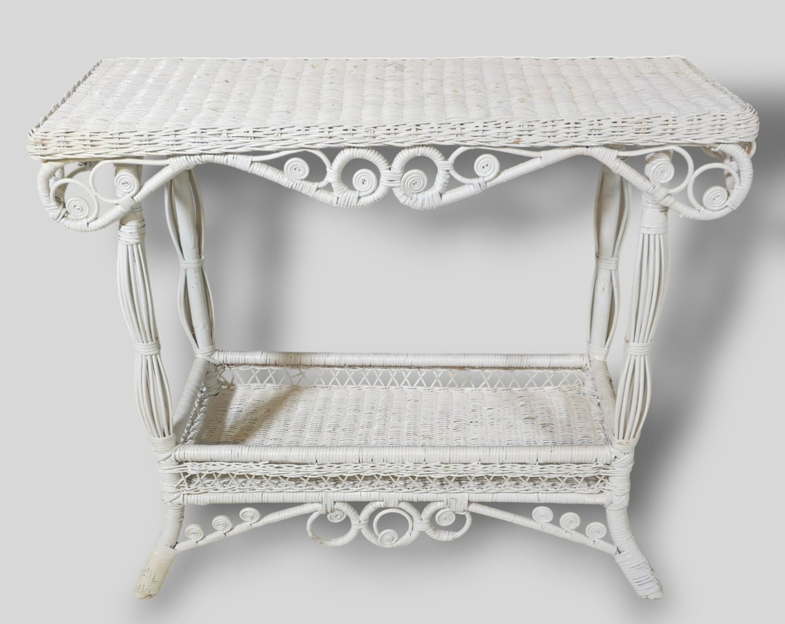 White Wicker Console / Sofa Table: White Wicker Console / Sofa Table. Aesthetic Movement style influences. Scrolled aprons and lower shelf. 36 1/2w x 14 1/2d x 31h.