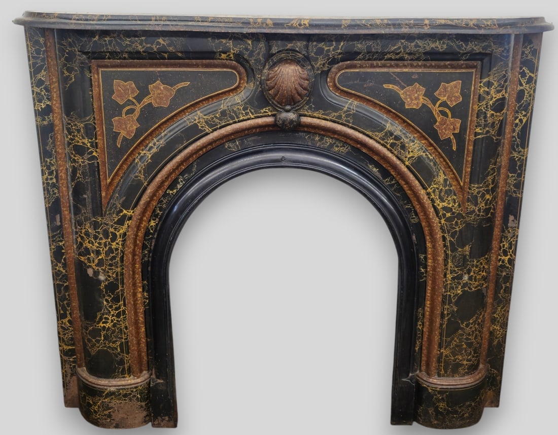 1920s Cast Iron Fireplace Mantel: Picture coming soon! 1920s Cast Iron Fireplace Mantel. Sculpture top over a raised high relif shell. Flanked by two panels and over an arched opening. Hand painted marblized decoration and ivy vines. 