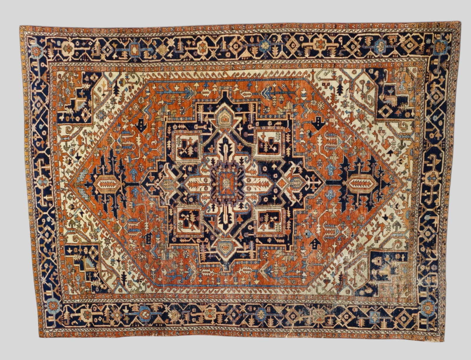 Heriz Area Rug: 1920s Heriz Area Rug. All over geometric and garden design over a red field and Navy medallion. Multiple layer borders. 9ft 2in x 11ft 9in.