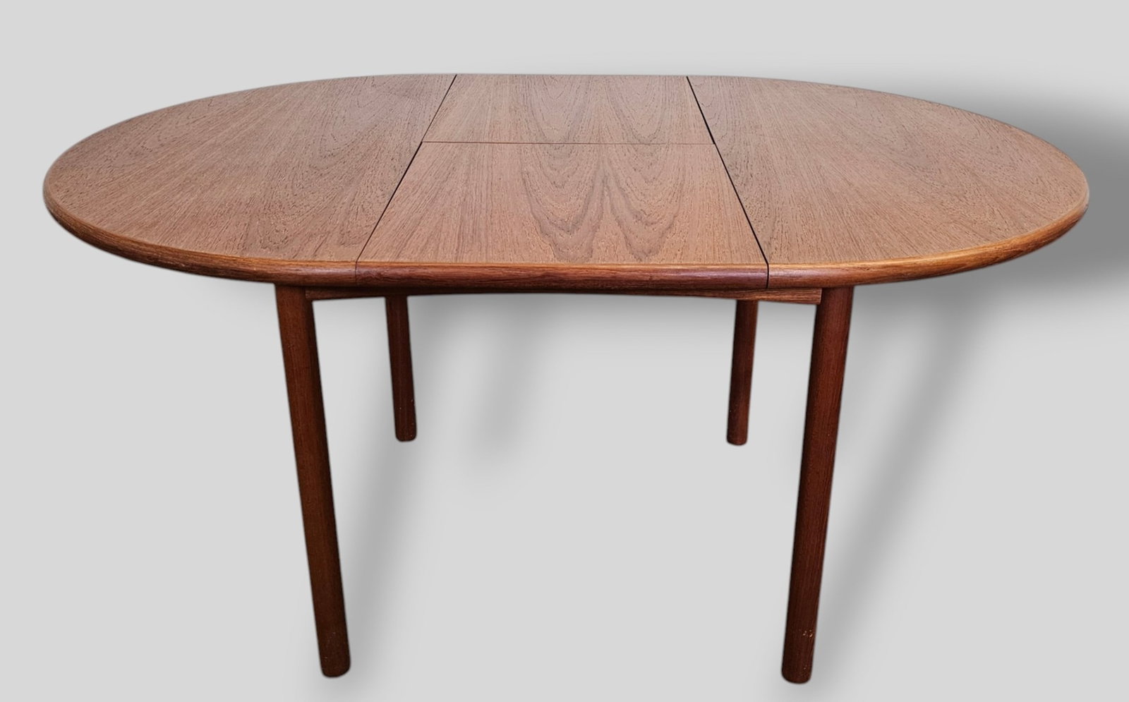 MCM Danish Teak Round Dining Table: MCM Danish Teak Round Dining Table. Denmark, 1960s. Self storing leaf-18 inches. Closed 42 1/4 dia x 29 3/8h. Oval shape fully extended 60 inches.