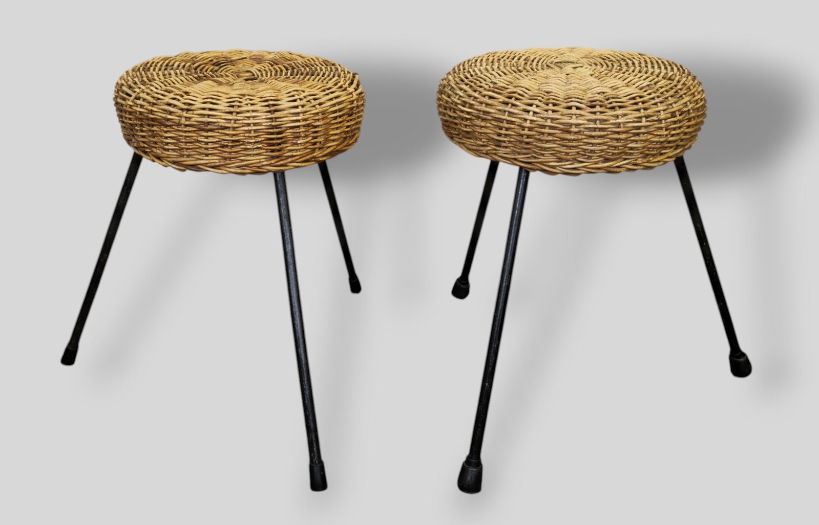 MCM Rattan and Wicker Stools: MCM Rattan and Wicker Stools. Pair. USA. 1950s. Wicker and enameled iron. 17 1/3 dia x 15h.
