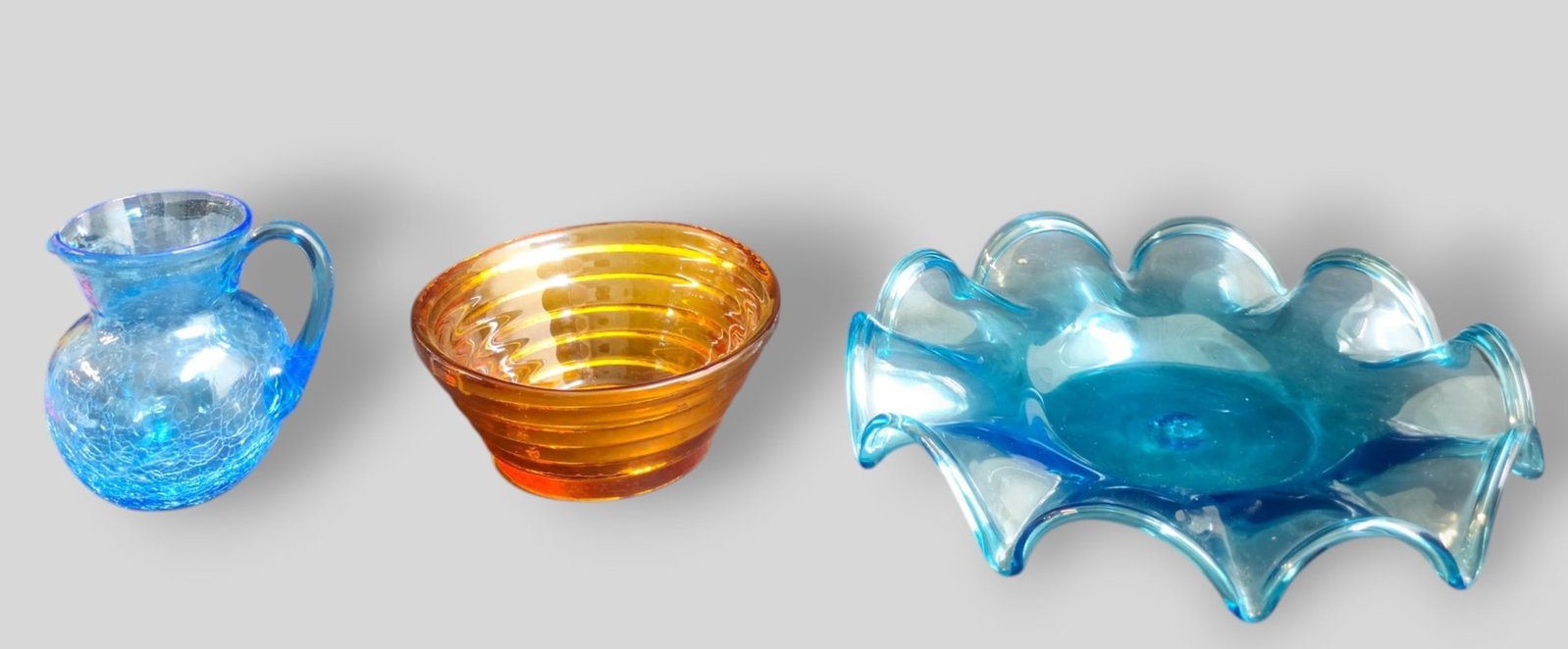 Assembled Blenko MCM Glass: Assembled Blenko MCM Glass. 3 piece total. USA. Amber ring bowl, 1980s. 6 1/2 dia x 2 3/4h. Scalloped blue tray. 1960s. 11 1/4 dia x 2h. Creamer 4 5/8 w x 4 d x 4 3/4h.