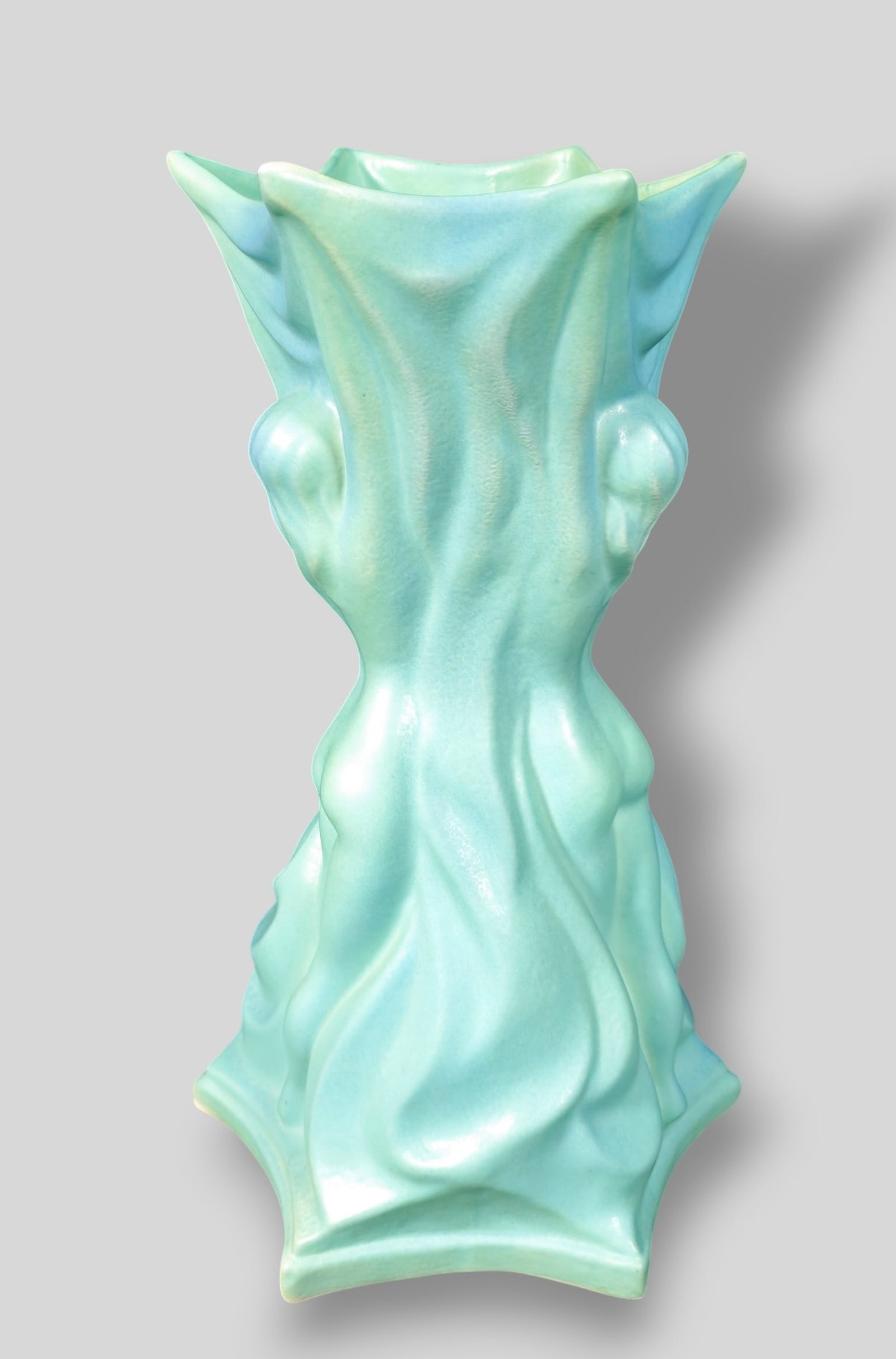 Van Briggle Art Pottery Three Graces Vase: Van Briggle Art Pottery Three Graces Vase. Sculptured drapes with three outstretched ladies on 6 prong base. Manufacturer's mark to underside. 10w x 10d x 17h.