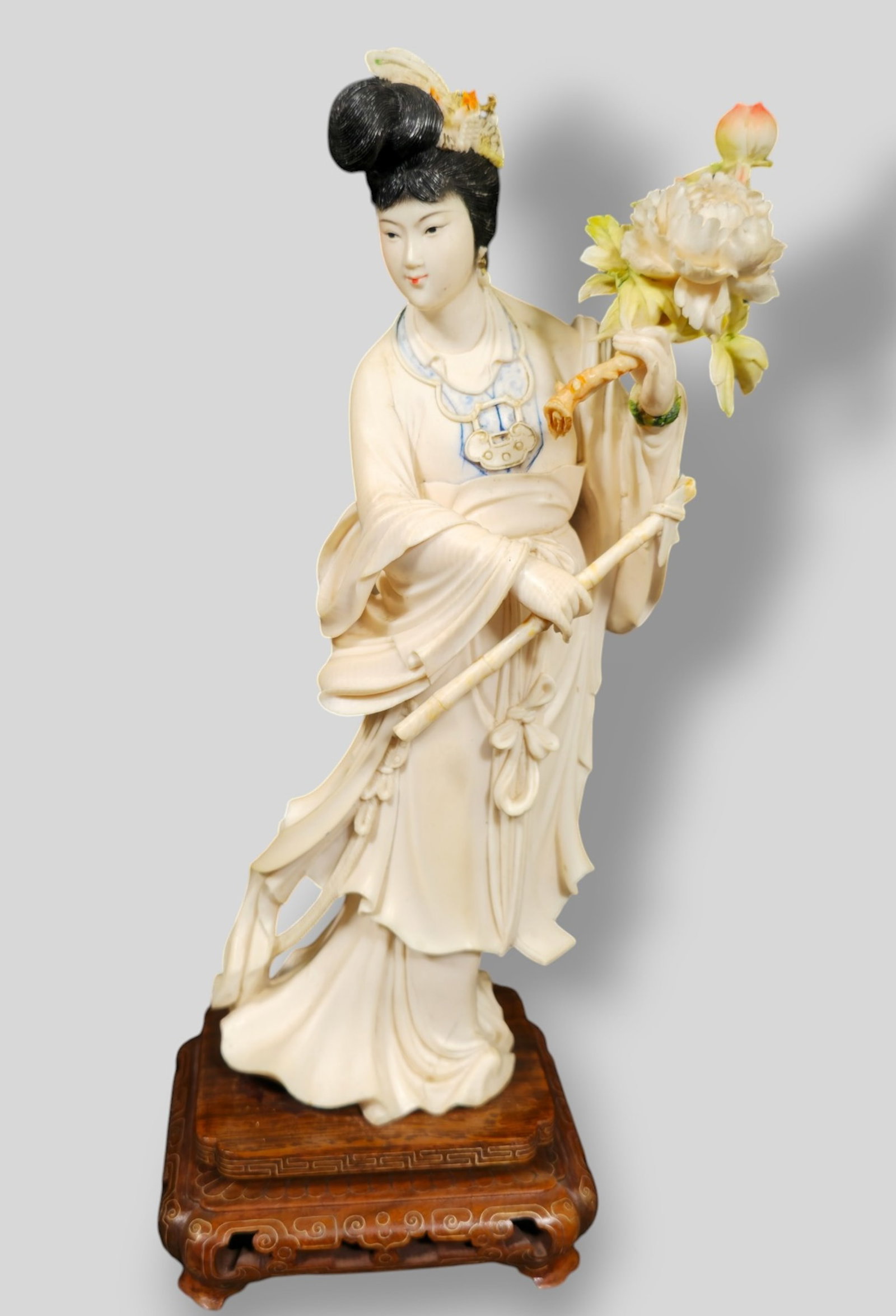Chinese Intricately Carved Geisha Lady with Flowers: Chinese Intricately Carved Geisha Lady with Flowers. Excellent detail and dyed pigments. Raised on teak base with brass inlay. Figurine 5w x 3d x 10h. Overall 5 1/2w x 4 1/2d x 11 7/8h.