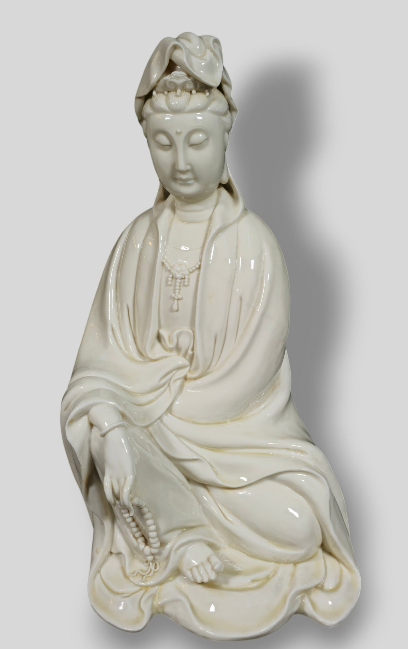 Chinese Blanc de Chine Porcelain Seated Guanyin: Chinese Blanc de Chine Porcelain Seated Guanyin. Wearing beaded necklace and robe. 10w x 9d x 18h.
