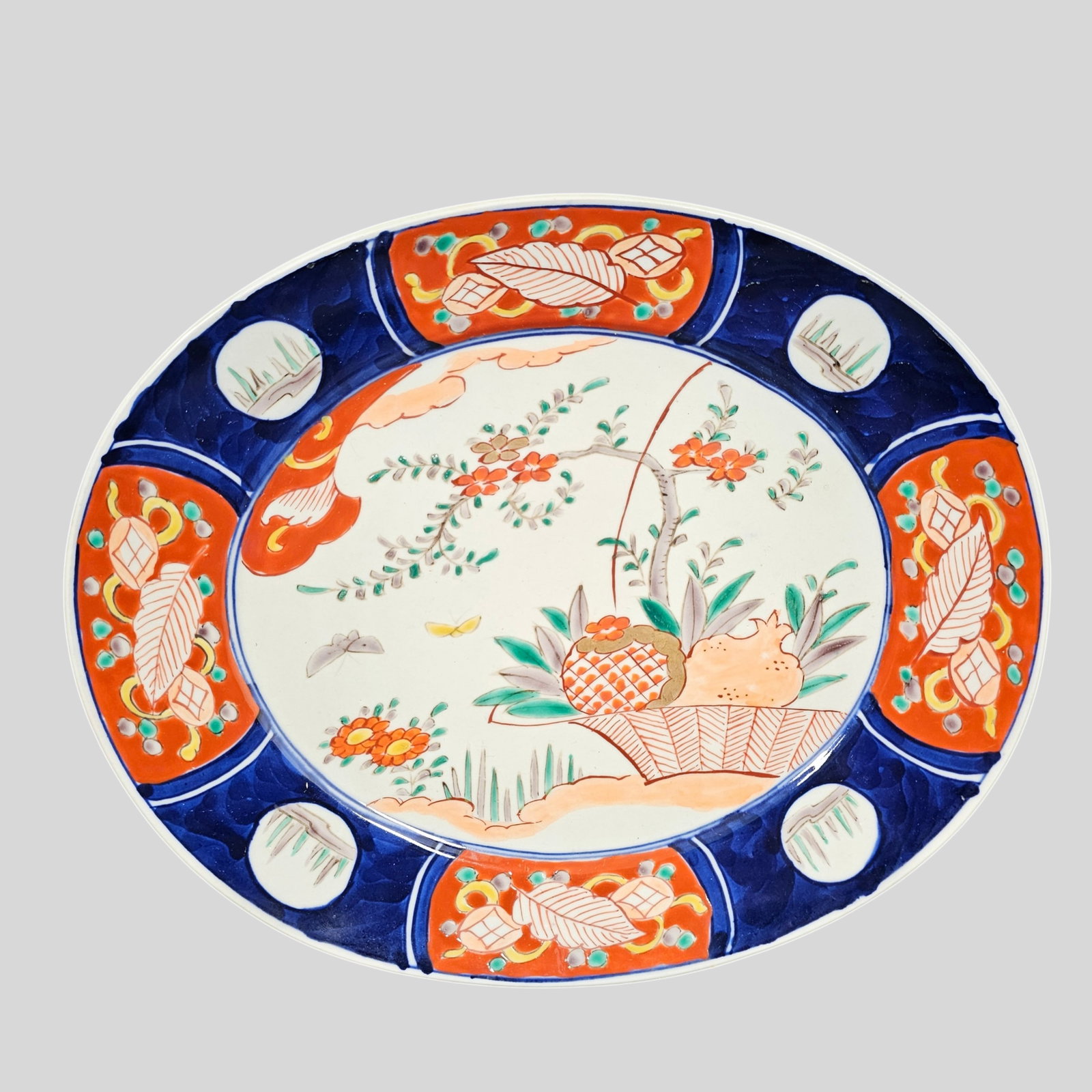 19th Century Japanese Imari Oval Platter: 19th Century Japanese Imari Oval Platter. Circa 1880. Red and blue border. Flowering tree and fruit basket. 13 1/4w x 11d x 1 1/2h.