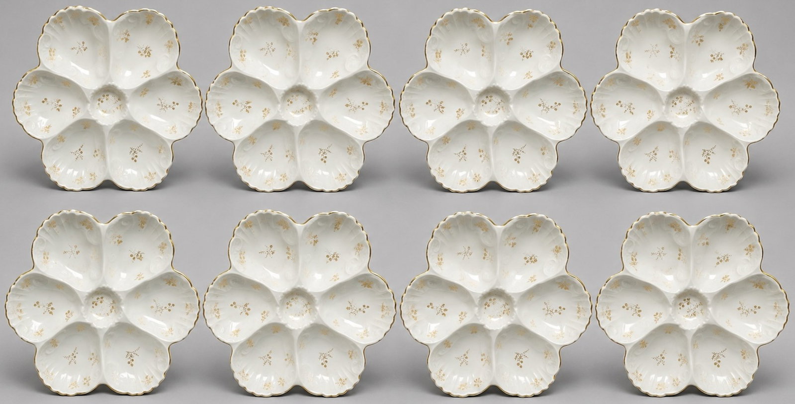 Limoges Porcelain Scalloped Oyster Plates: Limoges Porcelain Scalloped Oyster Plates. Set of 8. Circa 1890-1910. Gilt border and flowers. Limoges marked to underside. 9 1/2w x 8 1/2d x 1 1/2h.
