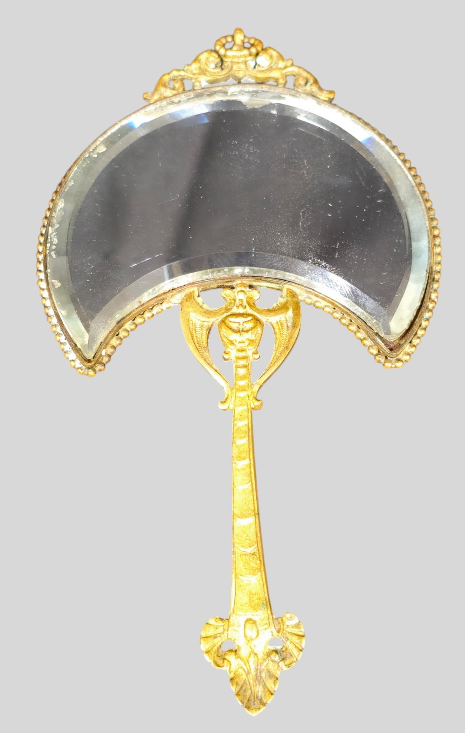 Sèvres Porcelain Vanity Hand Mirror: Sèvres Porcelain Vanity Hand Mirror. Crescent Form. Winged griffins and metal fittings. Artist signed on porcelain. Beveled glass crescent mirror. 3 3/4w x 7h.