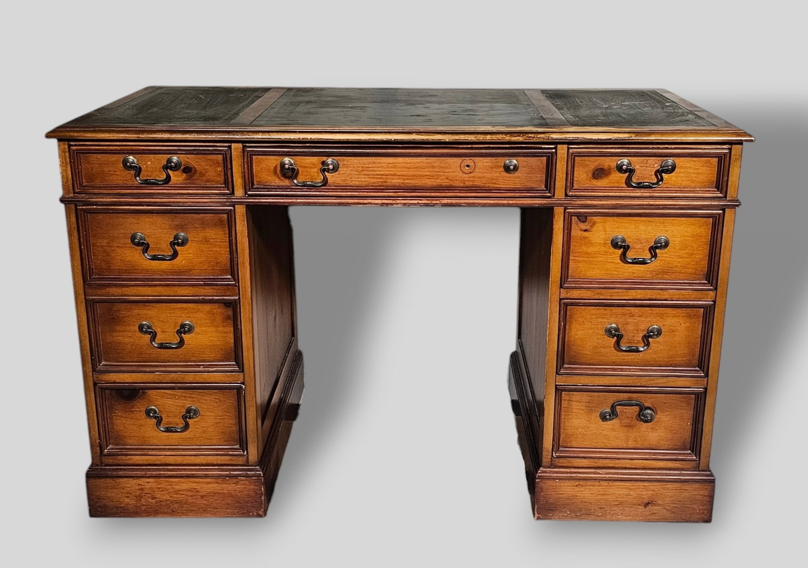 Sligh Lowry Green Leather Desk: Sligh Lowry Green Leather Desk. USA. 20th Century. 8 drawers. Green tooled leather panel top. Manufacturer's mark to drawer. Walnut and brass pulls. 48w x 24d x 30h.
