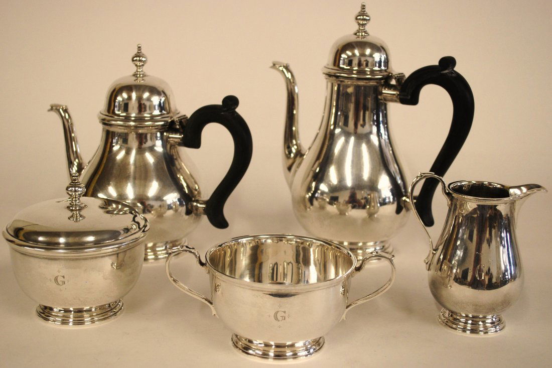 Tiffany & Company Sterling Tea Set: Five piece tea set, pear shape with ebony handles. Set includes coffee pot, tea pot, covered sugar, creamer, and waste bowl. All Marked "Tiffany & Co. Makers Sterling Silver" with various shapes and n