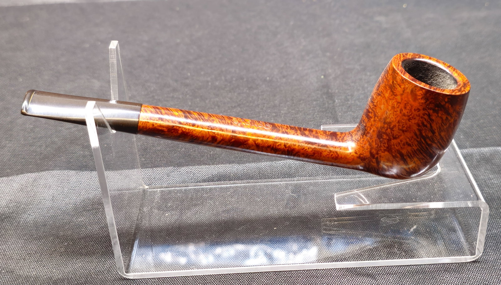 Comoy's Tiger's Eye: Comoy's Tiger's Eye. English briar tobacco pipe in a straight billiard shape with a warm reddish-brown finish and highly figured grain throughout. Fitted with a black mouthpiece bearing the Comoy's
