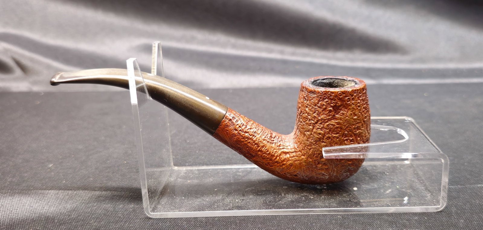 Dunhill Tanshell 120: Dunhill Tanshell 120. English briar tobacco pipe with light tan sandblasted finish and bent stem. Stamped "120 Dunhill Tanshell Made in England 4T." Manufacturer’s mark to pipe.