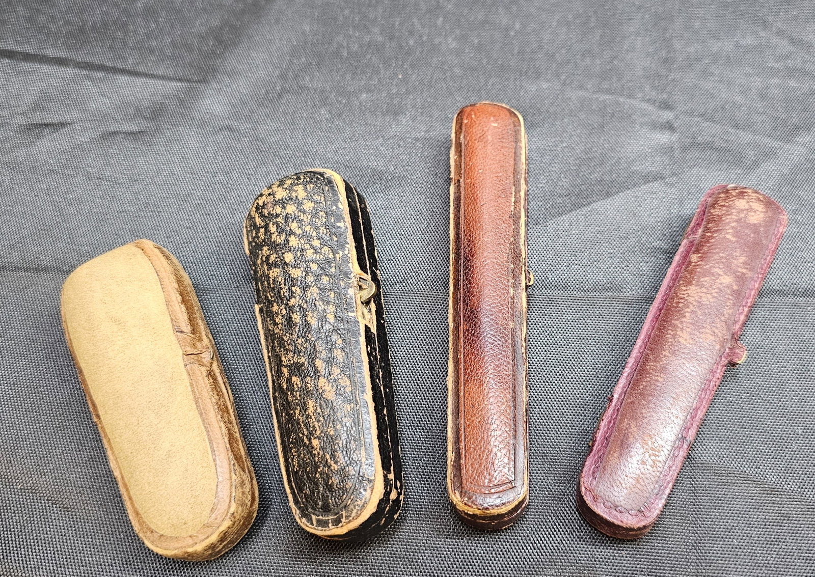 Assembled Group of Cased Smoking Mouthpieces and Cases: Assembled Group of Cased Smoking Mouthpieces and Cases. Includes two elongated smoking mouthpieces or holders, one in amber-colored material with gold-tone band and one in dark brown material with