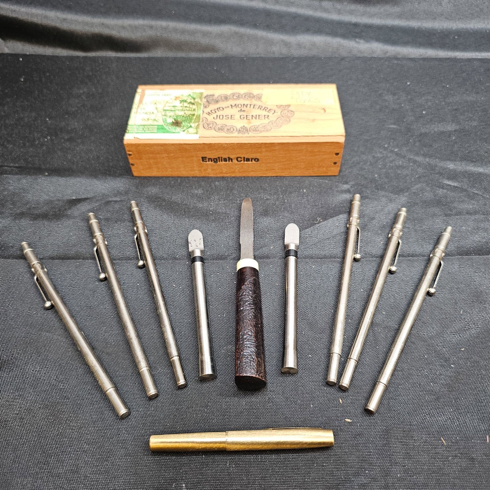 Assorted Pipe Tools in Hoyo de Monterrey Cigar Box: Assorted Pipe Tools in Hoyo de Monterrey Cigar Box. Collection of assorted tobacco pipe maintenance tools including metal tampers, reamers, scrapers, picks and cleaning implements, all housed together