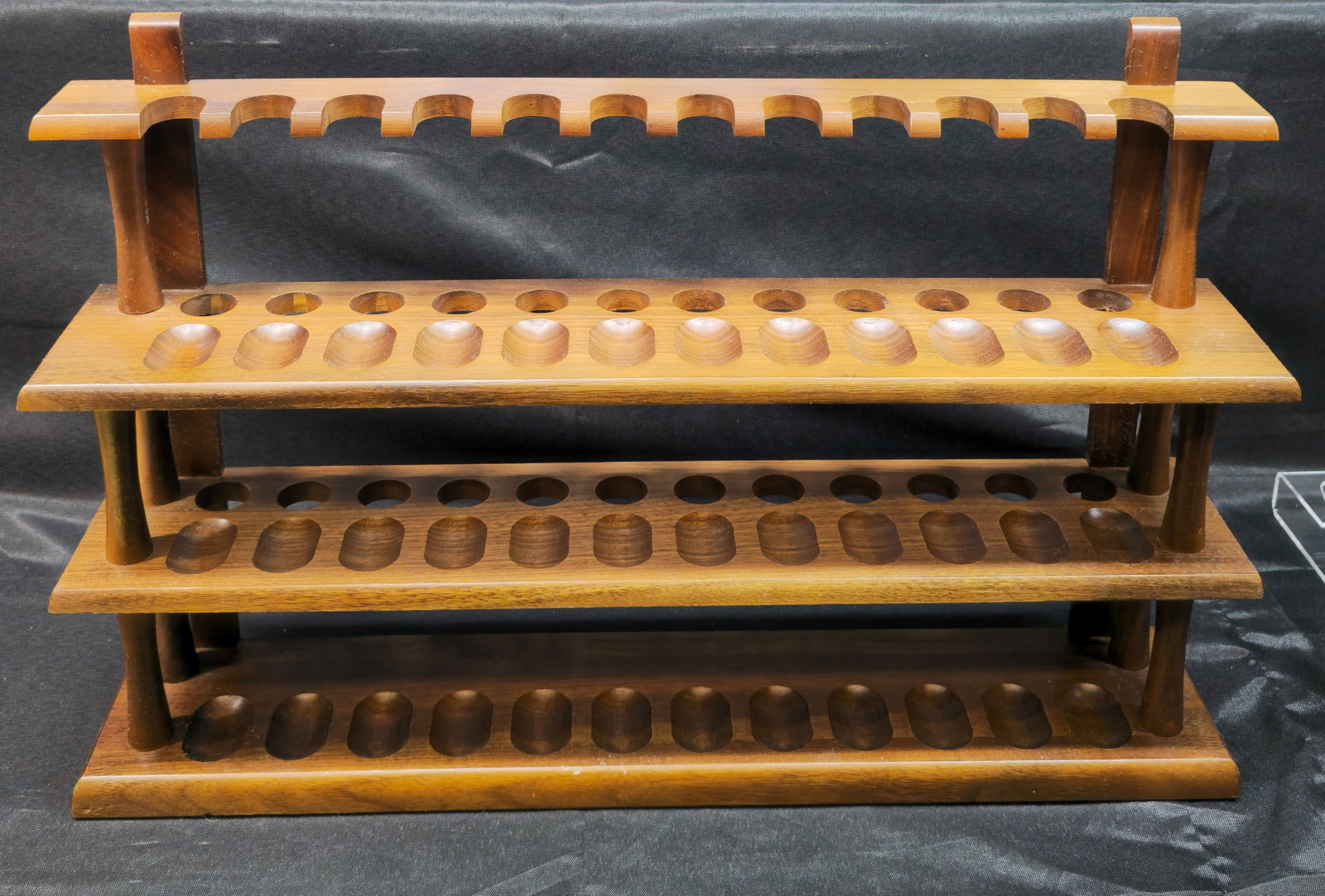 Three-Tier Wooden Smoking Pipe Display Rack: Three-Tier Wooden Smoking Pipe Display Rack. Large wooden display and storage rack designed to accommodate approximately 36 smoking pipes across three tiers. Features a warm stained wood finish with i
