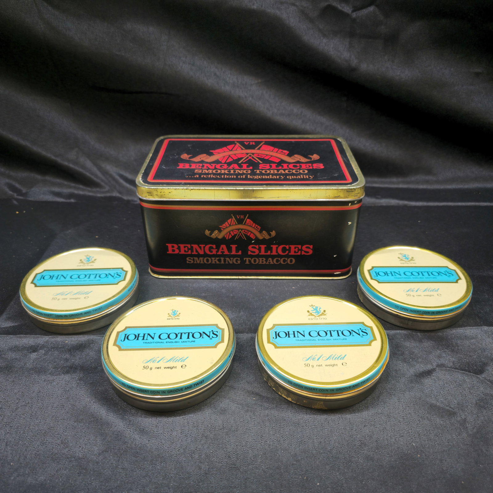 Vintage John Cotton's No. 1 Mild & Bengal Slices Tobacco Tins: Five vintage smoking tobacco tins comprising four John Cotton's Traditional English Mixture No. 1 Mild 50 g round tins and one larger Bengal Slices Smoking Tobacco rectangular tin. Colorful vintage