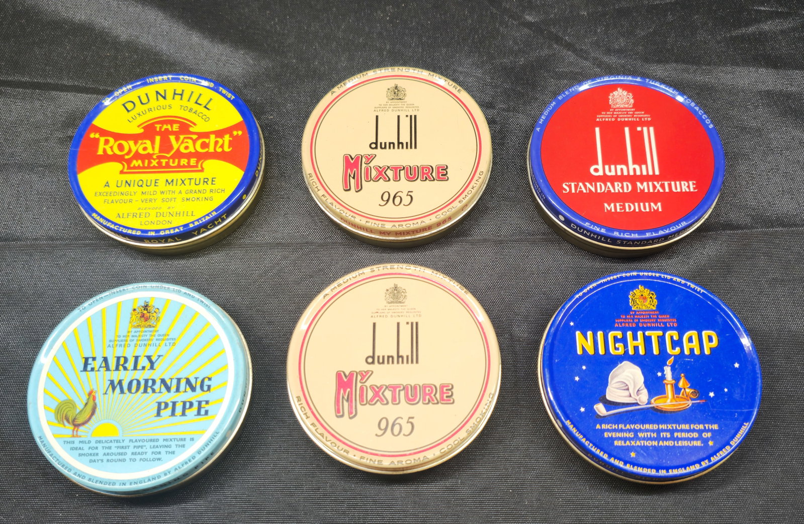 Collection of Six Dunhill Tobacco Tins: Collection of six Dunhill tobacco tins comprising The Royal Yacht Mixture, two My Mixture 965 tins, Standard Mixture Medium, Early Morning Pipe and Nightcap. Colorful vintage advertising tins with