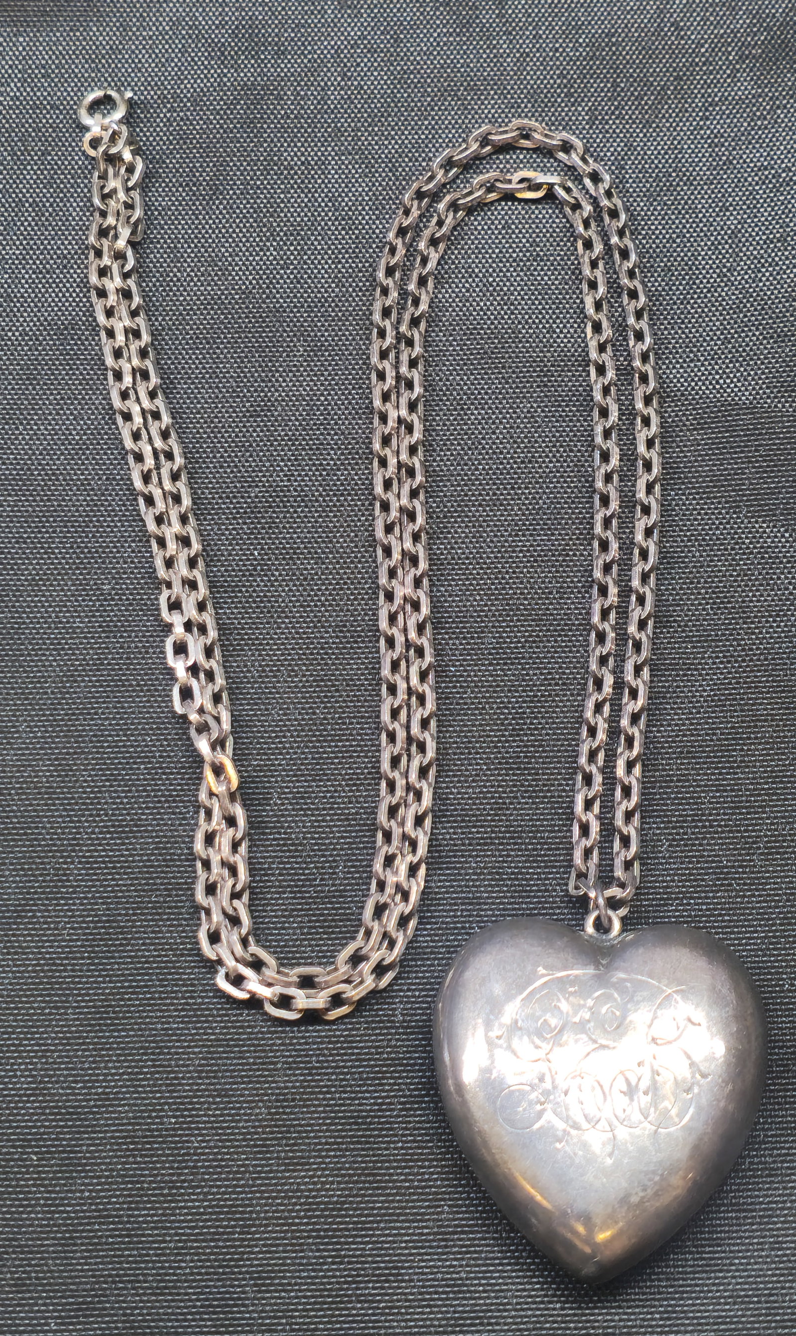 Sterling Silver Puffy Heart Pendant Necklace: Sterling silver necklace featuring a substantial double-link chain suspending a large dimensional puffy heart pendant with engraved decoration to front. Pendant marked “STERLING.” Total we