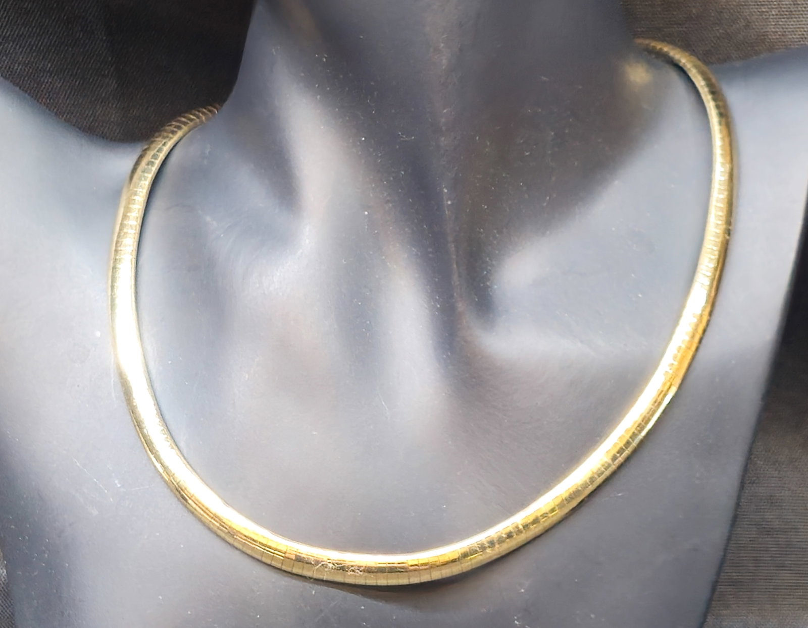 14K Yellow Gold Omega Necklace: 14K yellow gold Omega-style necklace featuring a flexible articulated flattened link design with box clasp and safety closure. Marked 14K to clasp, with additional maker's mark. 36.32 grams. 16" long.