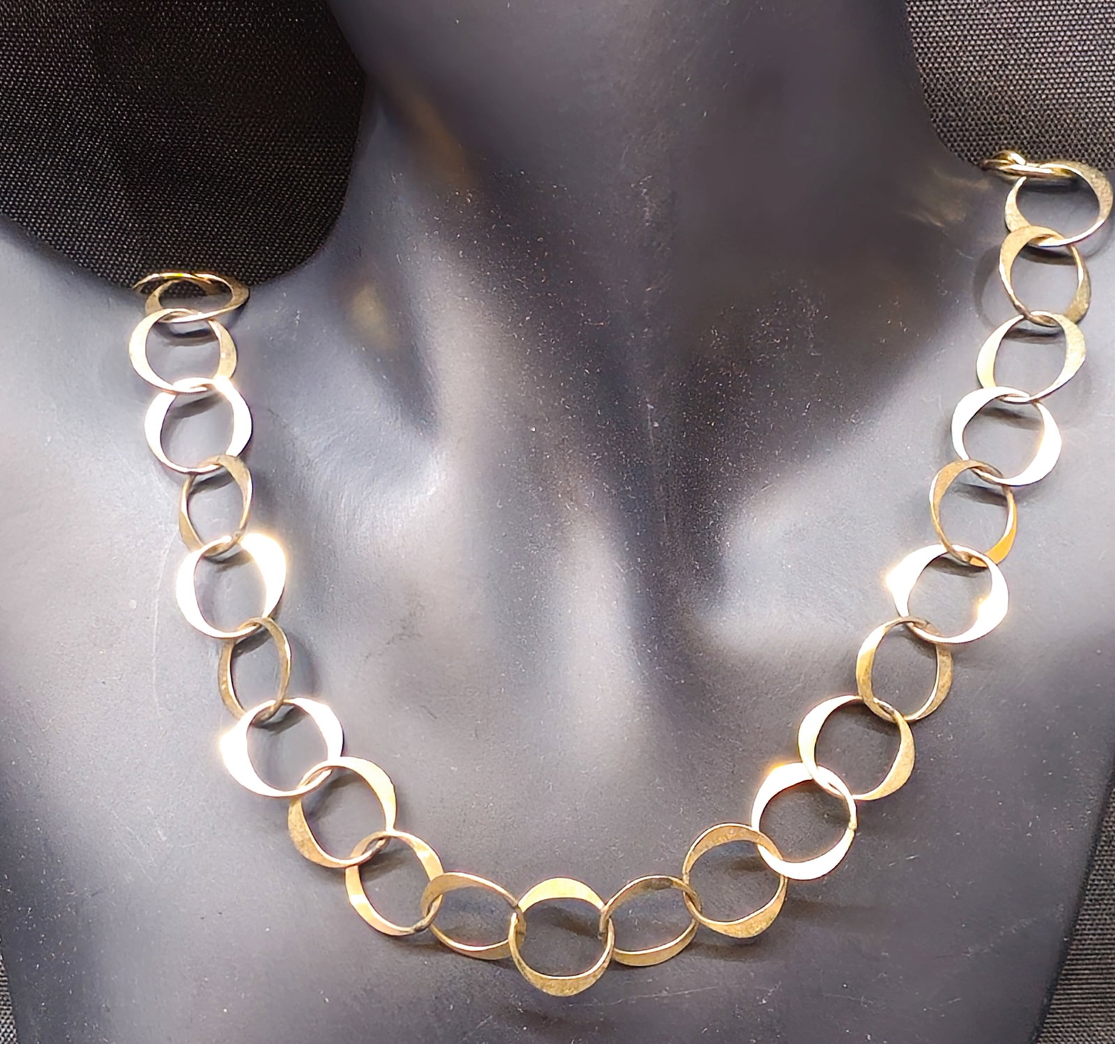 Handmade Yellow Gold-tone Circular Link Necklace: Handmade yellow gold-tone necklace featuring a continuous series of individually formed and flattened circular links, completed by a handmade hook-and-eye clasp