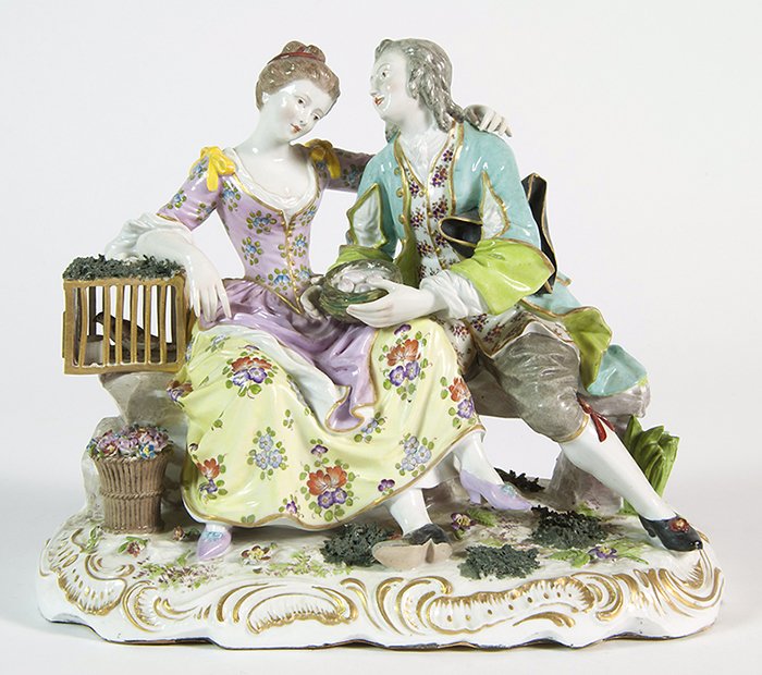 German Porcelain Figurine: Porcelain figurine of Romantic couple sitting on a bench. Marked with cross swords