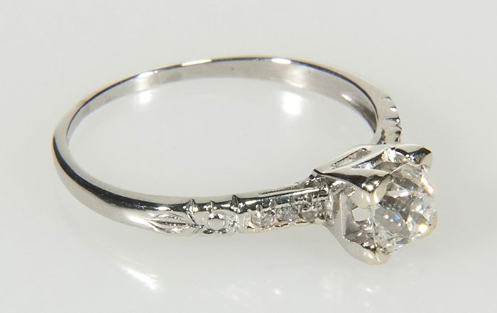 Antique Platinum and Diamond Engagement Ring: Ladies antique platinum and diamond engagement ring is size 8. Set in an Art Deco design, center diamond is old mine cut, approx., .79 cts, SI2 clarity and I color. 8 accent diamonds, single cut, are 