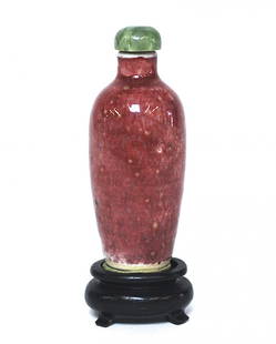 19th Century Snuff Bottle: Porcelain with red glaze and green cap. Qing Dynasty. Size, 3.25H. Collection of Dr. Robert Kemper.