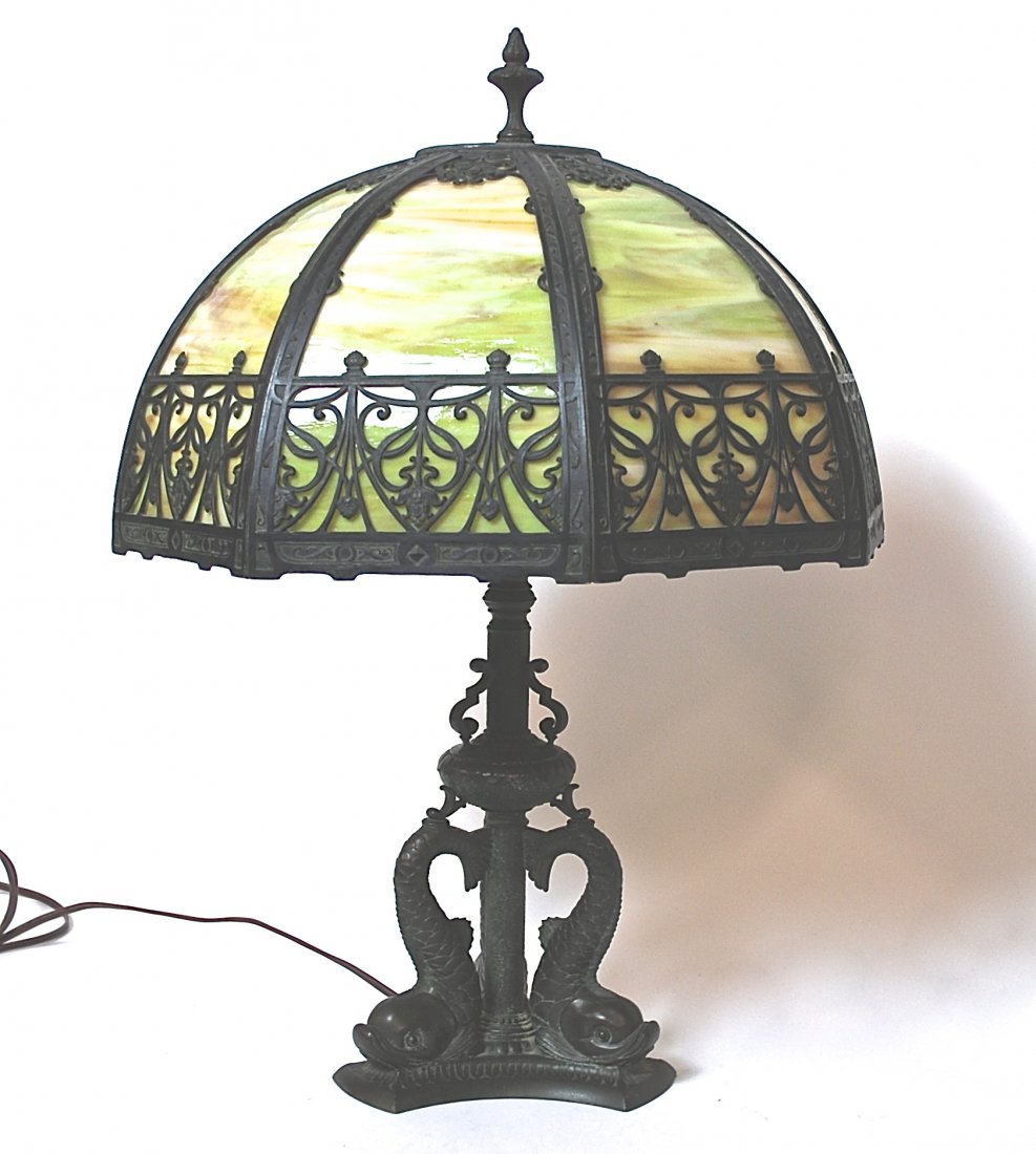 Pairpoint Table Lamp: Fine parlor lamp with bronze triple dolphin base. Bronzed slag base. Bronzed slag glass eight panel shade. (Marriage)Base signed. Literature: This base is illustrated: Edward and Sheila Malakoff, "Pai