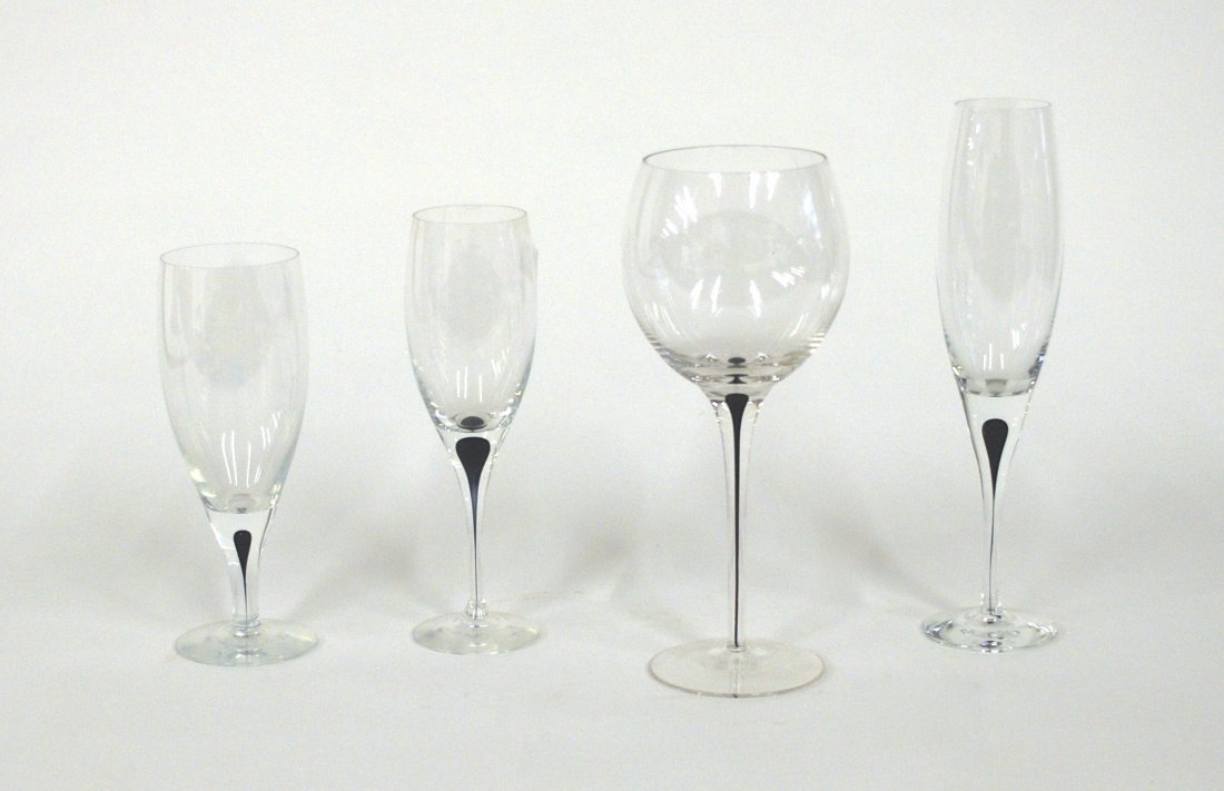 Orrefors Stemware: Thirty - one pieces total consisting of seven water glasses 7.25h, eleven champagne 9.75h, seven red wine 9h, three parfait 8.75h, three odd stems 8h. Crystal with ebony tear drop stems. Signed.