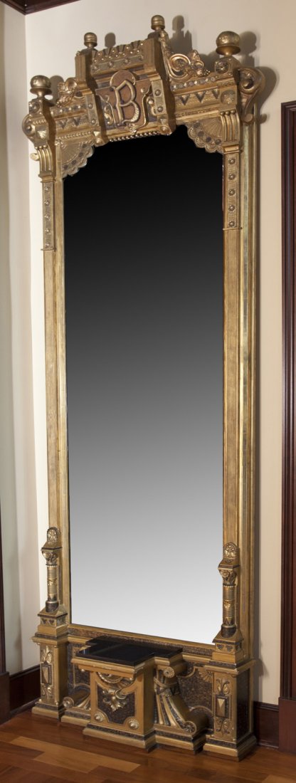 Monumental 19th Century Pier Mirror: Outstanding and fine gilded Victorian pier mirror with Aesthetic carvings and accents. Multiple carved floral medallions and scrolled cut-out base as well as scrolled carved accents. Ball and turned f