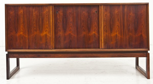 Komfort Rosewood Credenza: Danish credenza in rosewood. Three sliding doors. Pull-out serving trays to one side. Most likely designed by Helen Morgaard. Size 59w x 18.25l x 32h