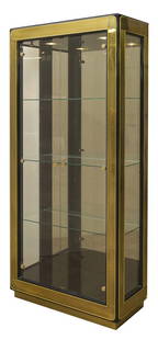 Baker Vitrine: Outstanding display cabinet. Illuminated interior, fitted glass shelves. Two glass doors. Two Manufacturers label, lacquered wood, brass, glass. Size 36w x 16.5d x 84h