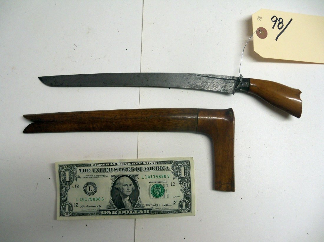 Antique 19th Century Indonesian Bade Bade Dagger: A Malayan knife with a narrow,incurved,single-edged blade sharp on the concave side. It has no guard and the blade on this example is 9 inches. Wood handle and scabbard. From the William Herbert McGin