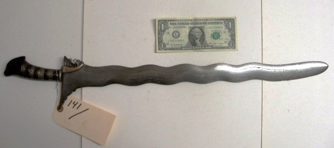 Fine Moro Kris Sword Dagger: 20 inch engraved blade with nicks to the edges of the blade from use.Carved horn handle with silver wrappings, Attractive weapon. From the William Herbert McGinty Collection. Collected between the lat