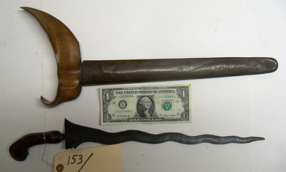 Antique 19th C. Bali Malaysian Kris Dagger Sword: 13½ inch watered blade, nicely carved handle in the traditional design. Wood nicely grained scabbard with brass covering. From the William Herbert McGinty Collection. Collected between the late 1800'