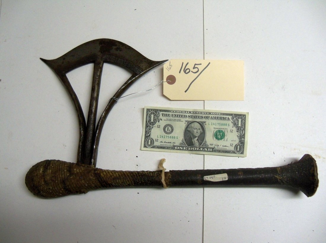 Songye Axe, Central African, Congo: Hand-forged iron blade. The haft with flared butt and bulbous head measures 16 inches and is covered overall with snake or lizzard skin. The blade extends 8 inches from the haft. From the William Herb