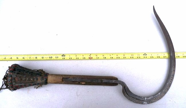 19th Century Unusual Antique African Ceremonial Sickle: 14½ inches at it's widest point, razor sharp edge with engraved designs and the date 1870 on the reverse side of the blade. Handsome, leather, cloth, leather fringe and interesting design tacks decor